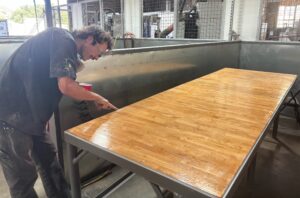 Student refurbishes worktable in the Hangar machine shop