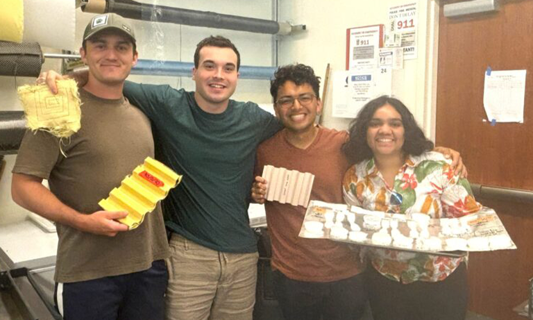 Four students pose in the Composites Lab with various materials