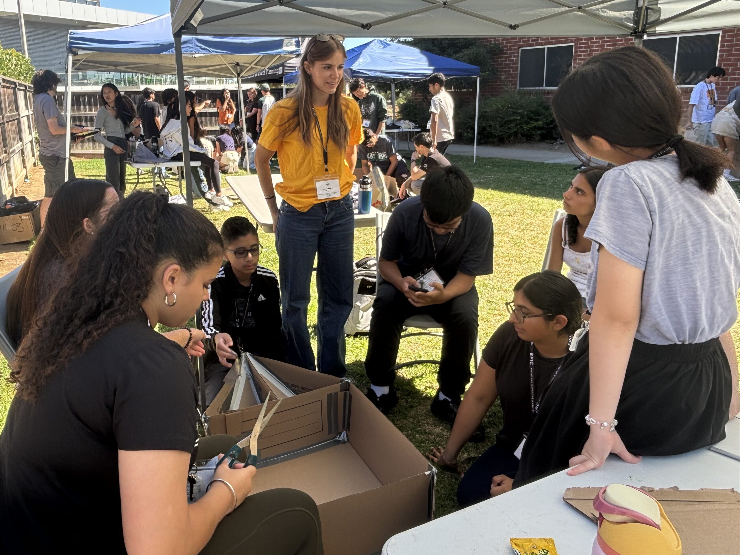 EPIC counselor advises her group as they construct their cardboard boat