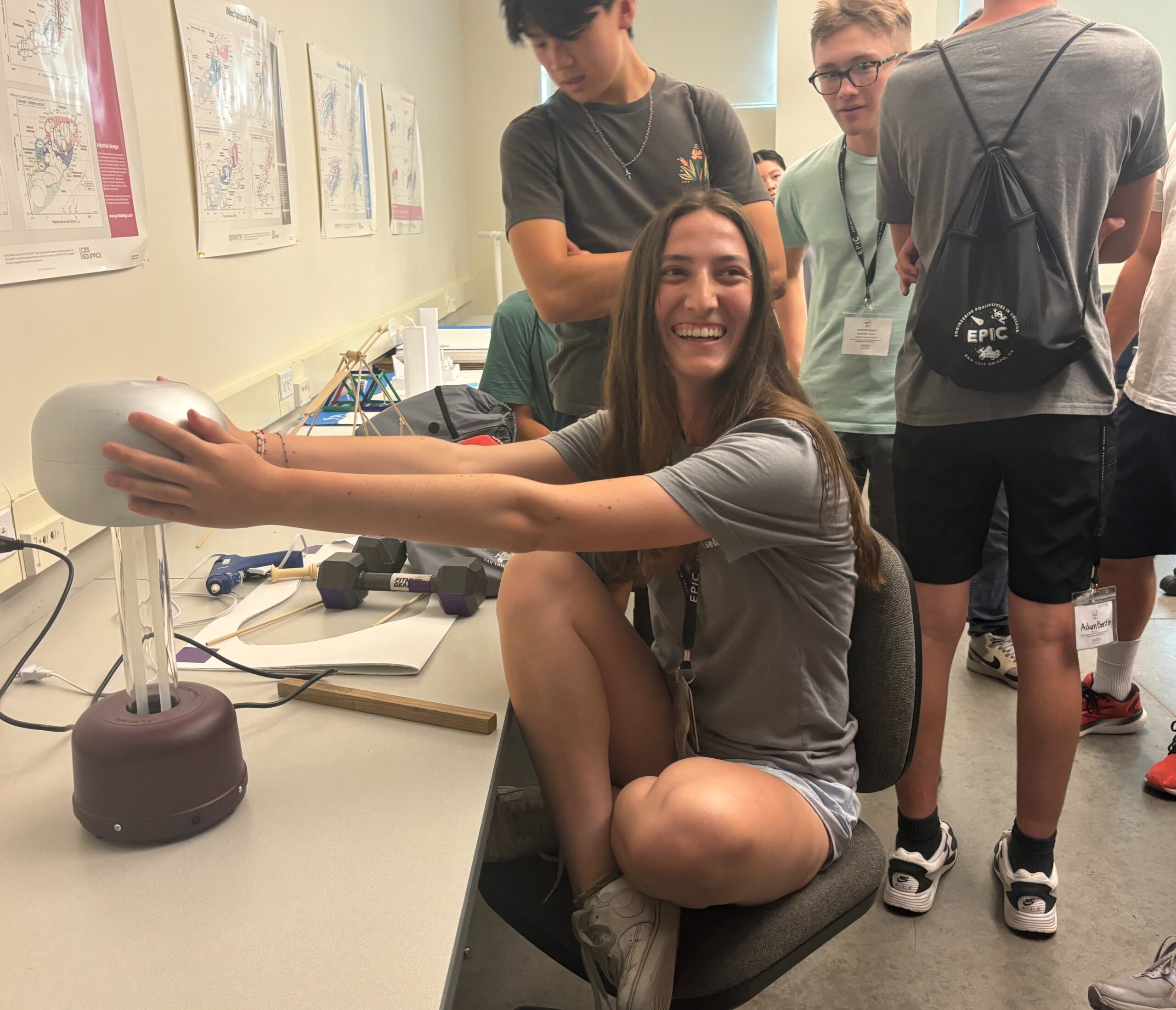 EPIC counselor places her hands on a Van de Graaff generator during the camp 