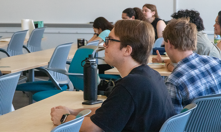 Students in a classroom looking at the front of the room.