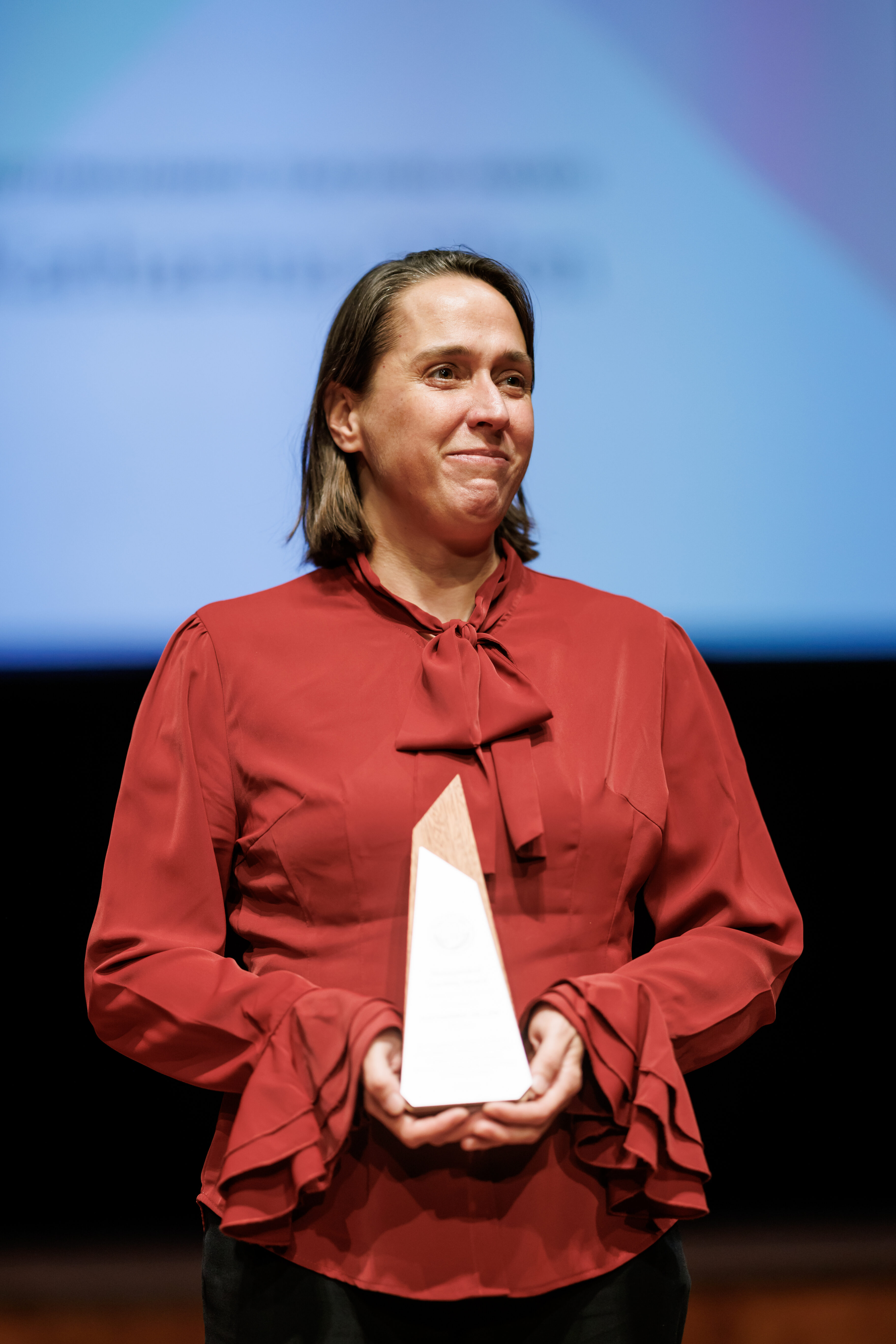 Professor stands onstage with her award