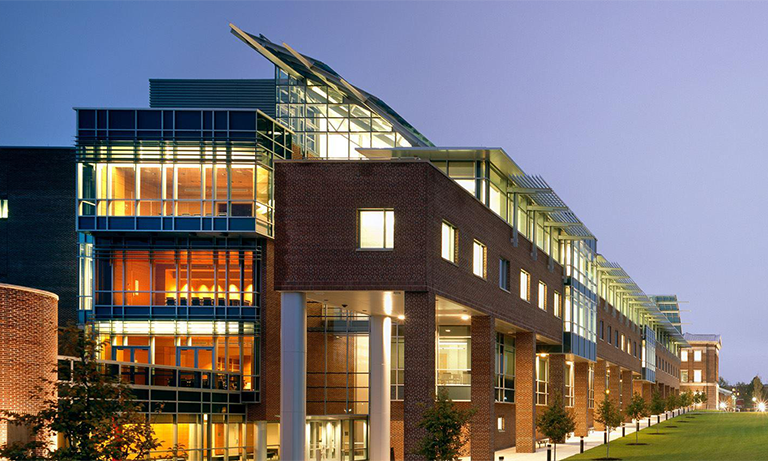 A building at dusk illuminated by lights.