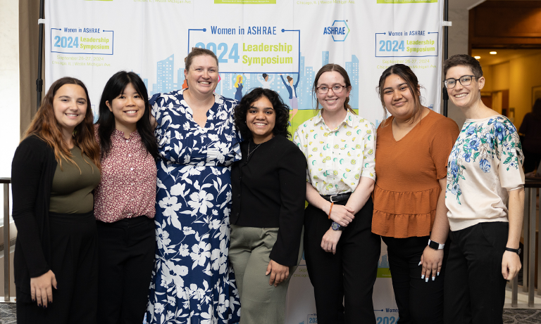 A group of people smiling for a picture at the ASHRAE Leadership Conference in front of a step-and-repeat.