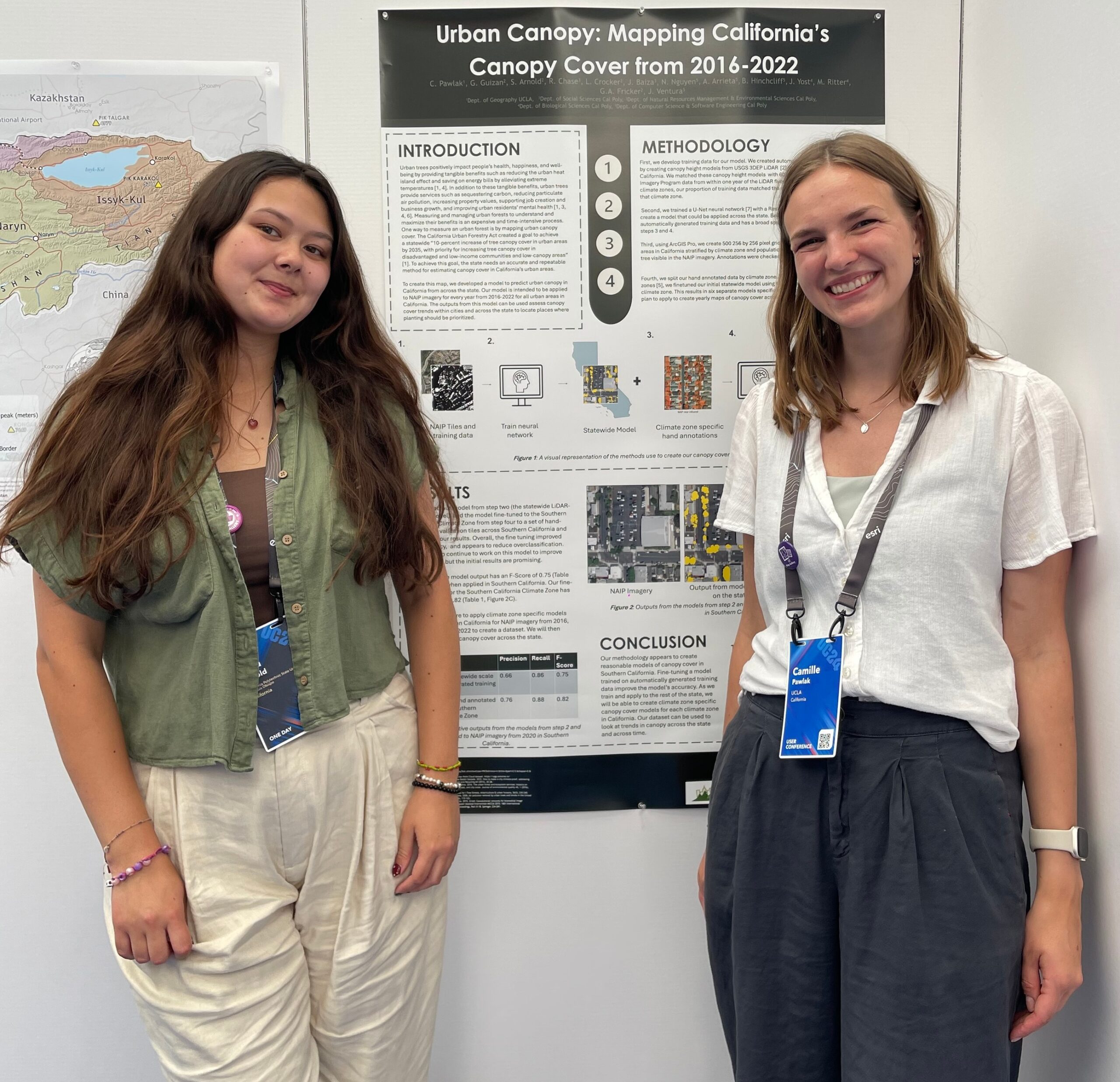 2 students present posterboard at conference