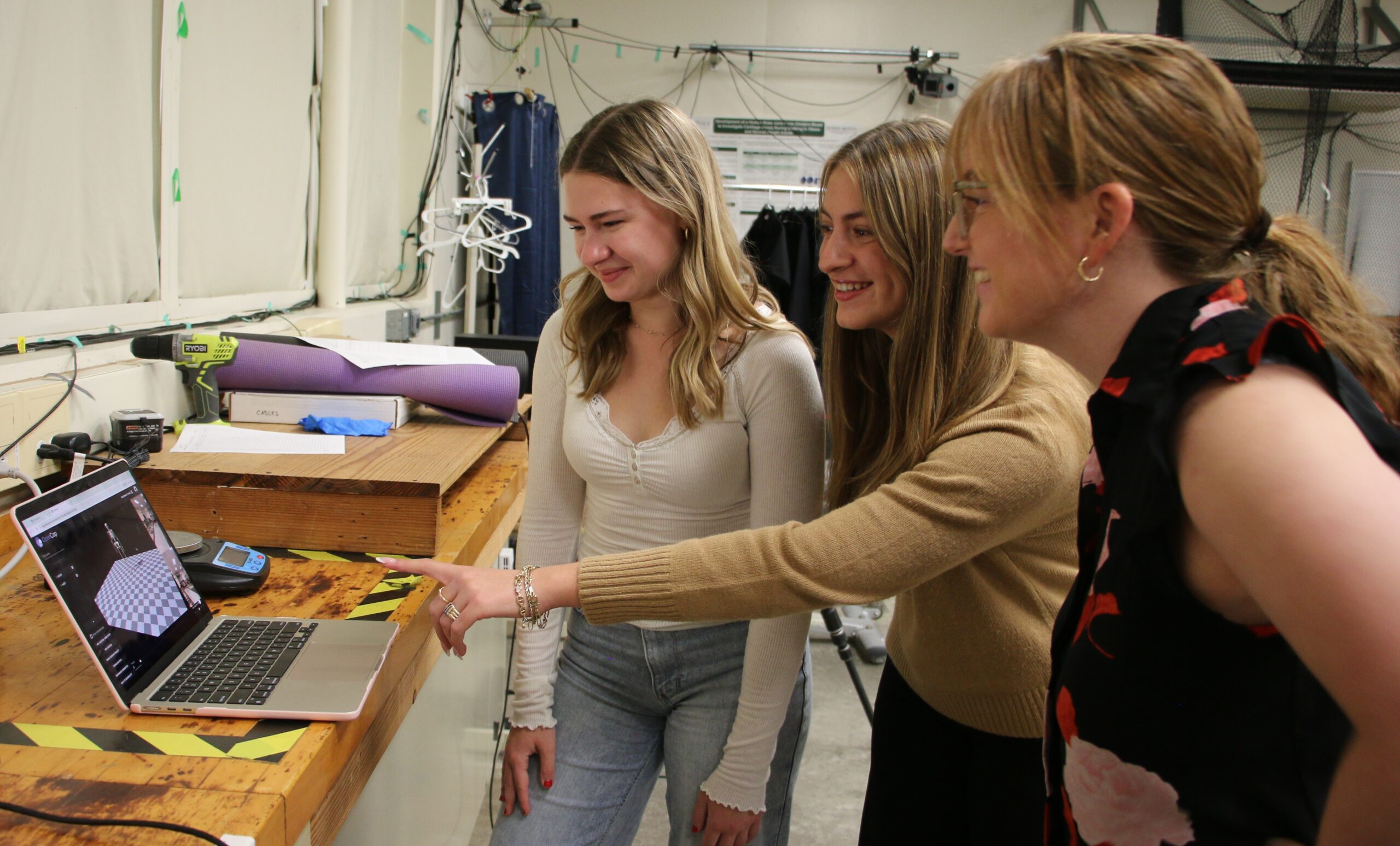 Professor and students look at data on a laptop