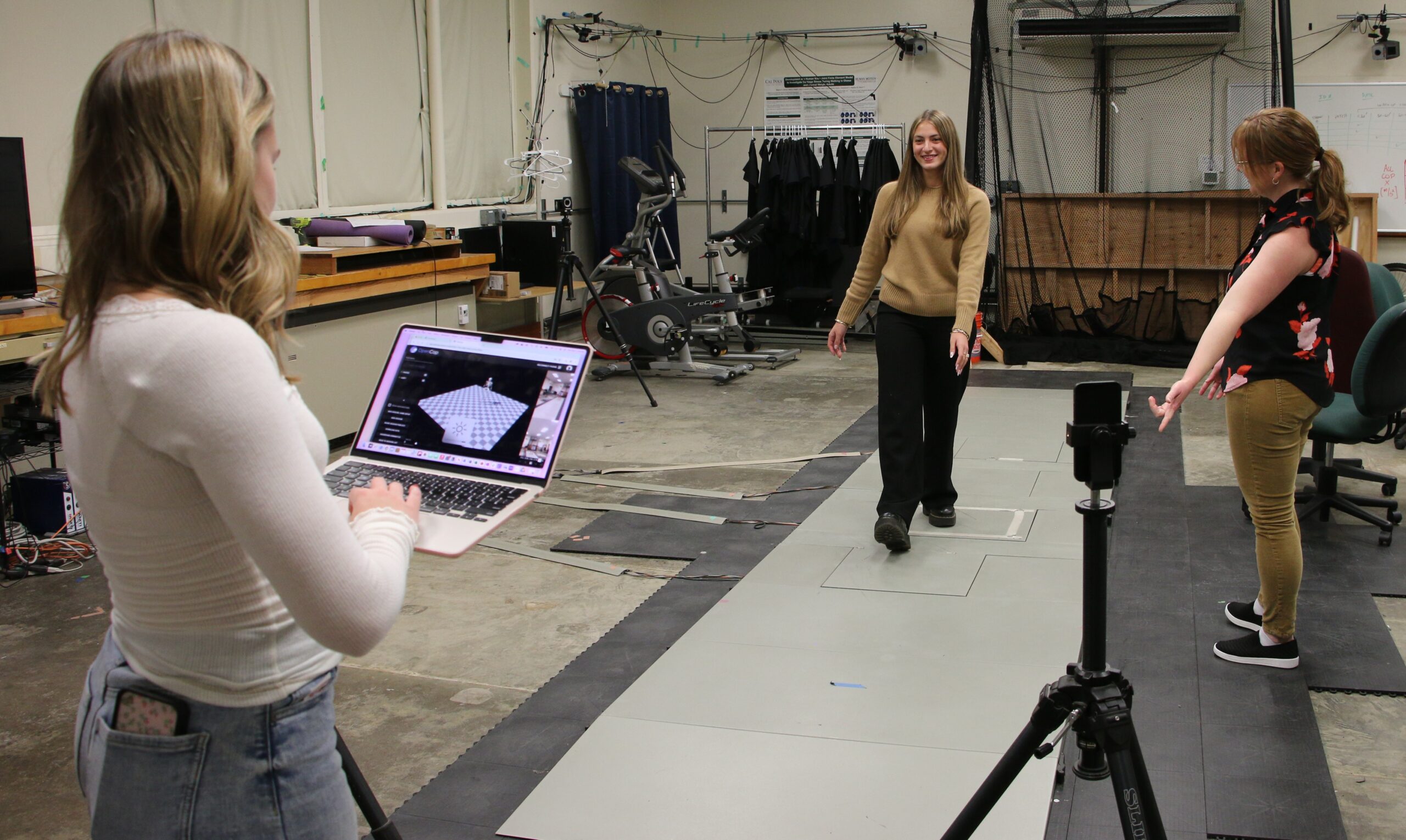 Professor directs student through a walking trial in the biomechanics lab 