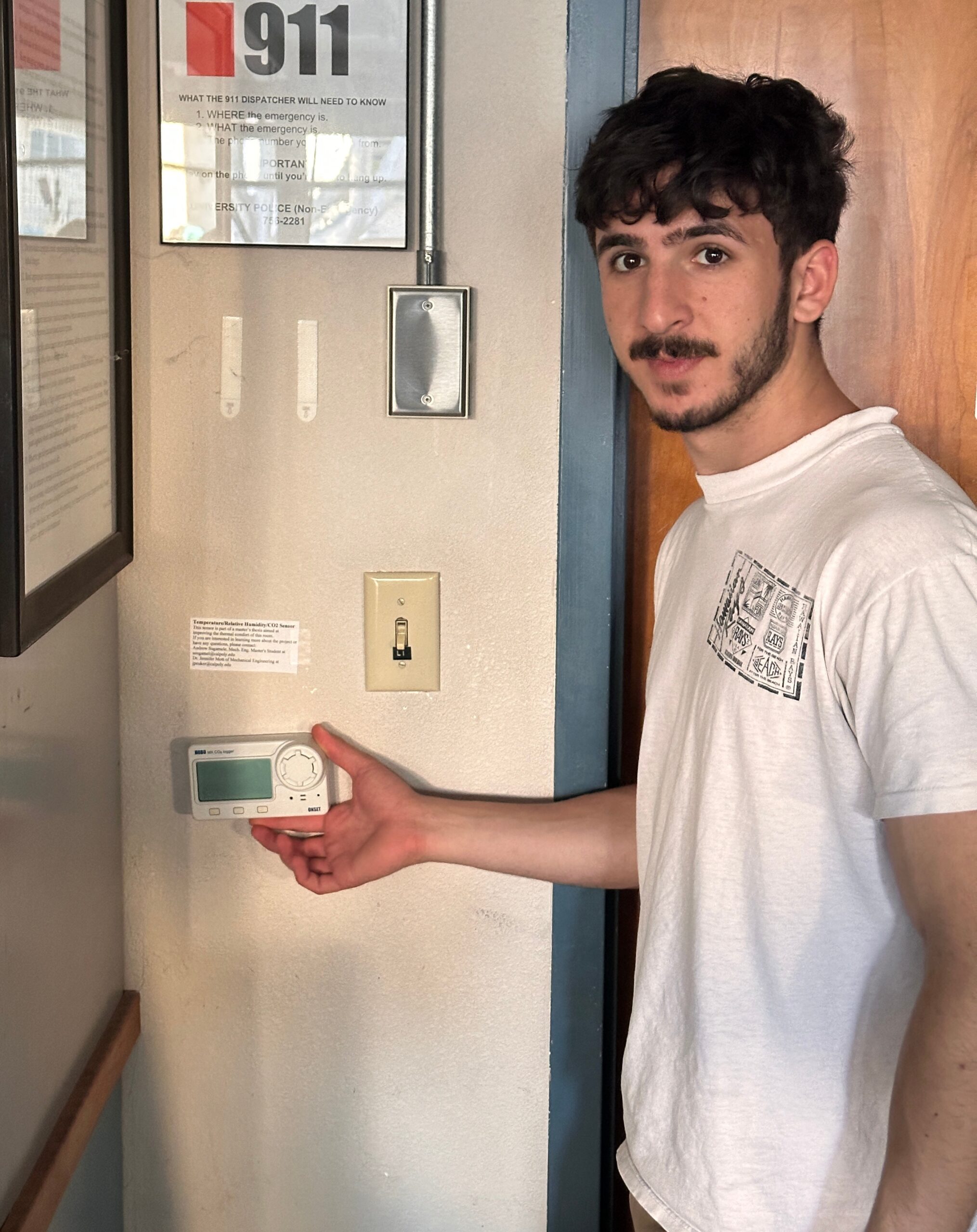 Mois Cohen, a mechanical engineering undergraduate student, checks a multi-function sensor that monitors temperature, relative humidity, and carbon dioxide levels. 