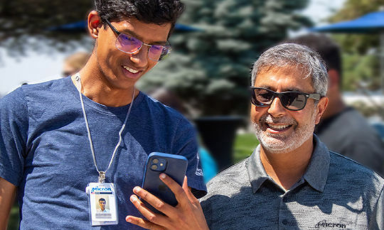 A stock photo of two people looking at a mobile phone.