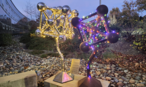 Holiday lights wrapped around two art installations.