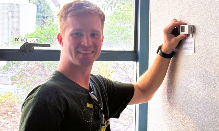 Mechanical engineering master’s student Andrew Sugamele sets up a multi-function sensor to monitor temperature, relative humidity and carbon dioxide levels in a room in Building 20.