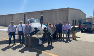 A group of people standing around a small plane.
