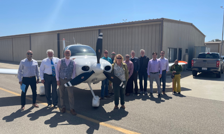 A group of people standing around a small plane.