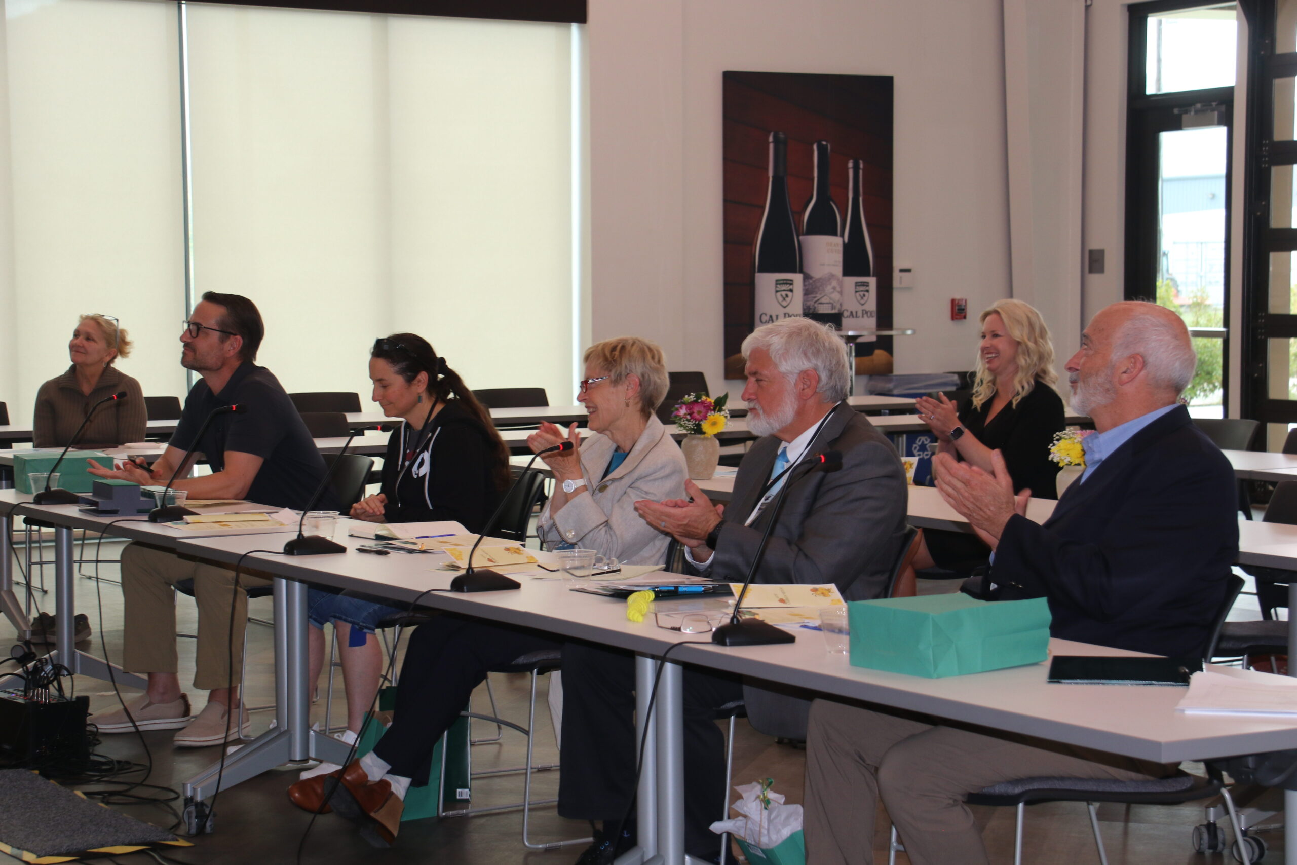 A group of people clapping after a presentation.