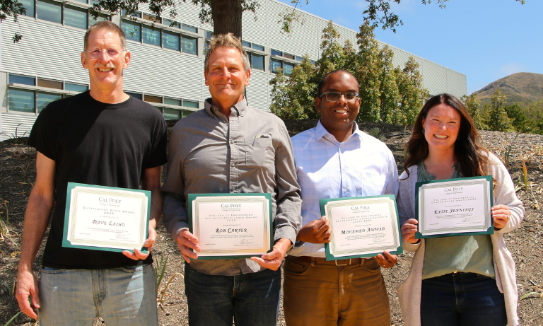 Four people holding up award certificates