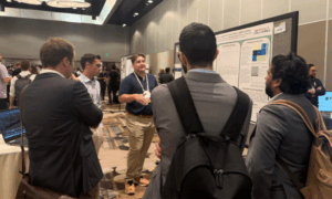 Students gathered around a poster at a conference