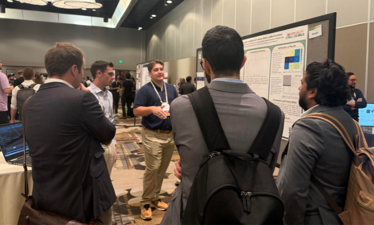 Students gathered around a poster at a conference