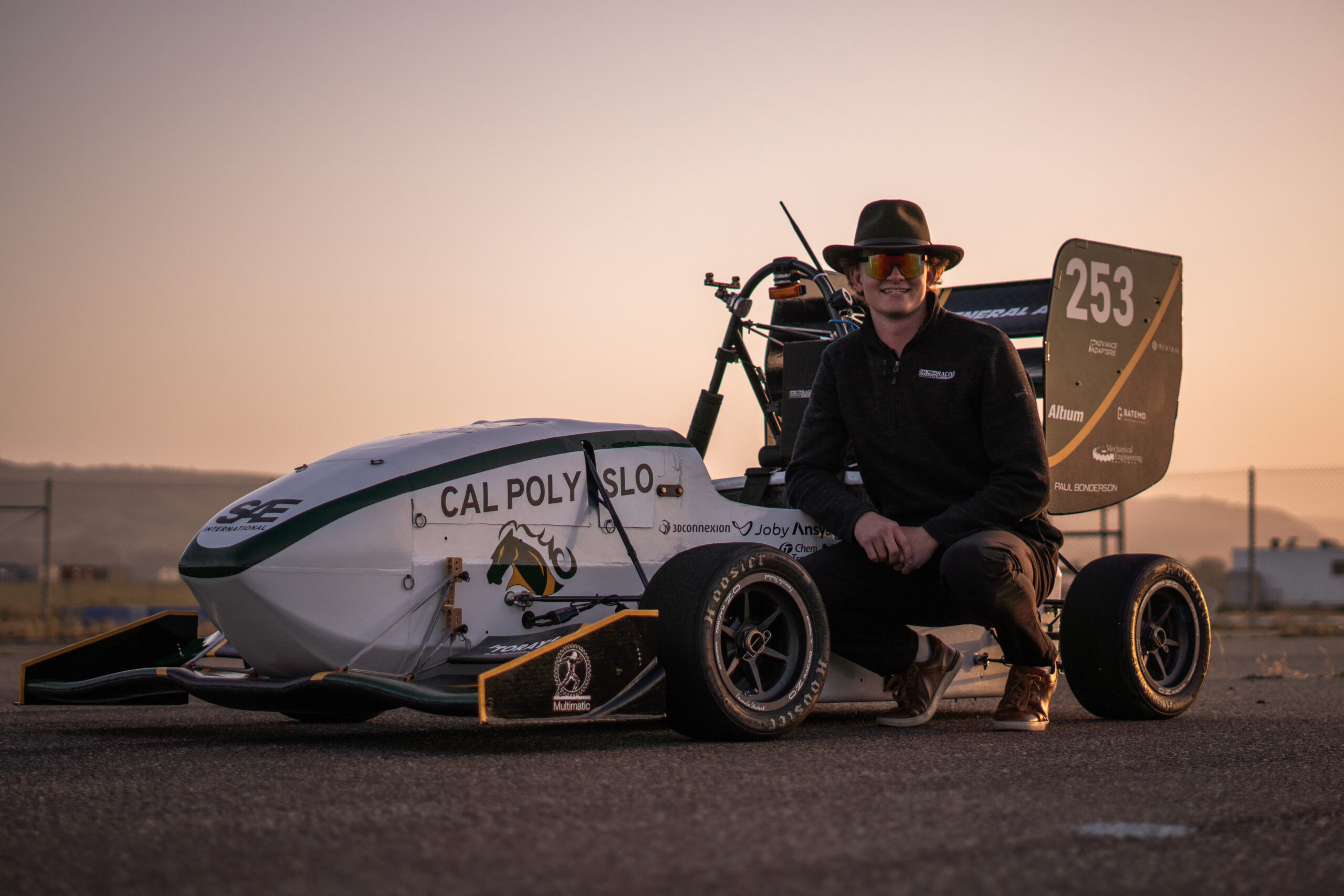 Team lead poses with race car after testing