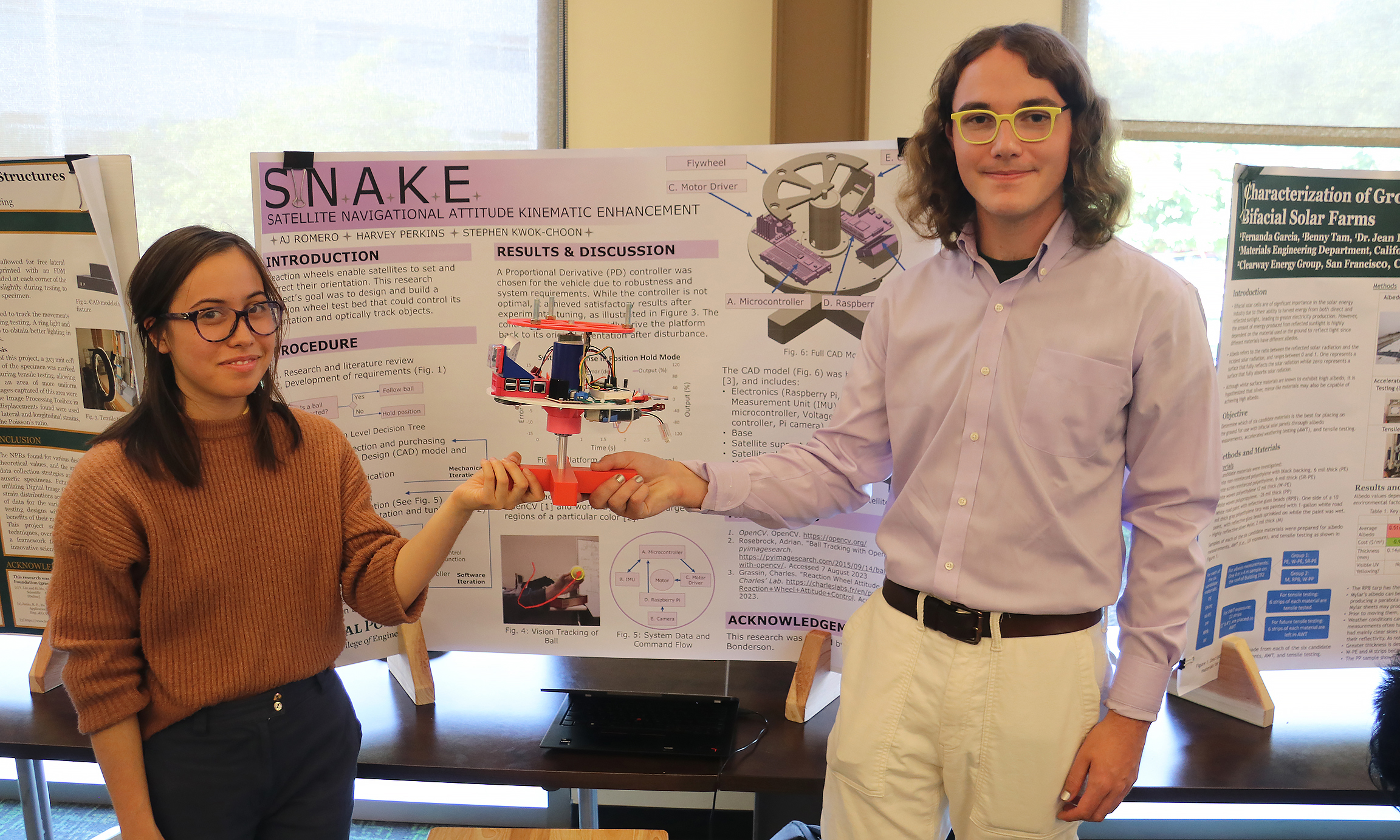 Two students in front of a poster