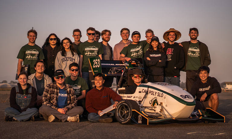 Team members gather around race car after testing