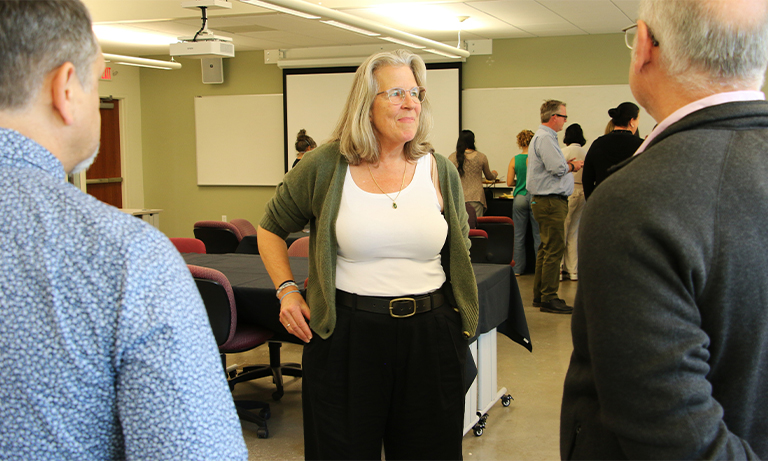 Professor interacts with staff and faculty at reception