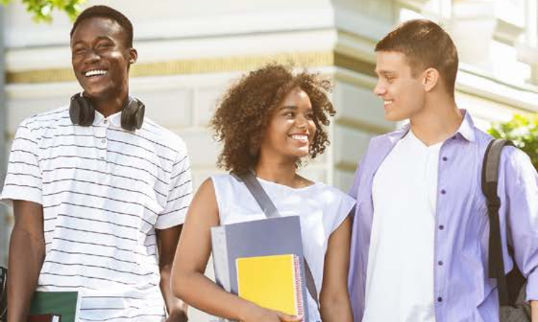 A stock photo of three students walking on a college campus.