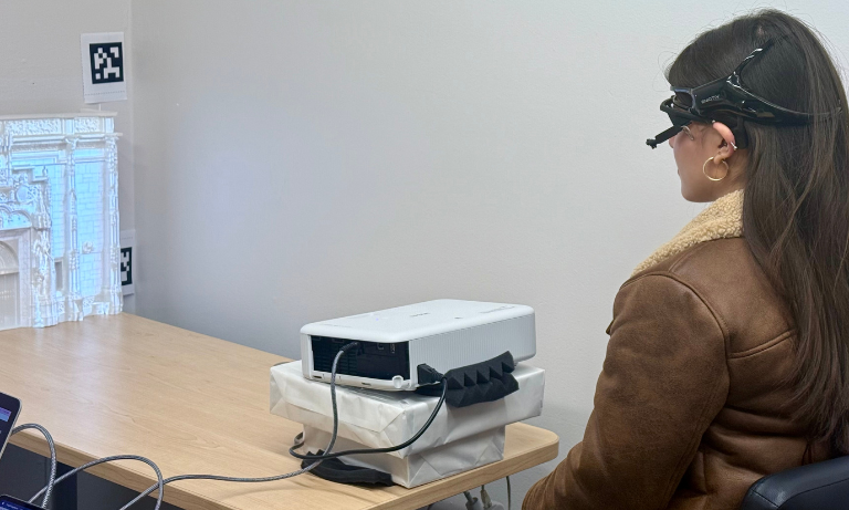 A student wearing an eye tracker facing away from the camera.