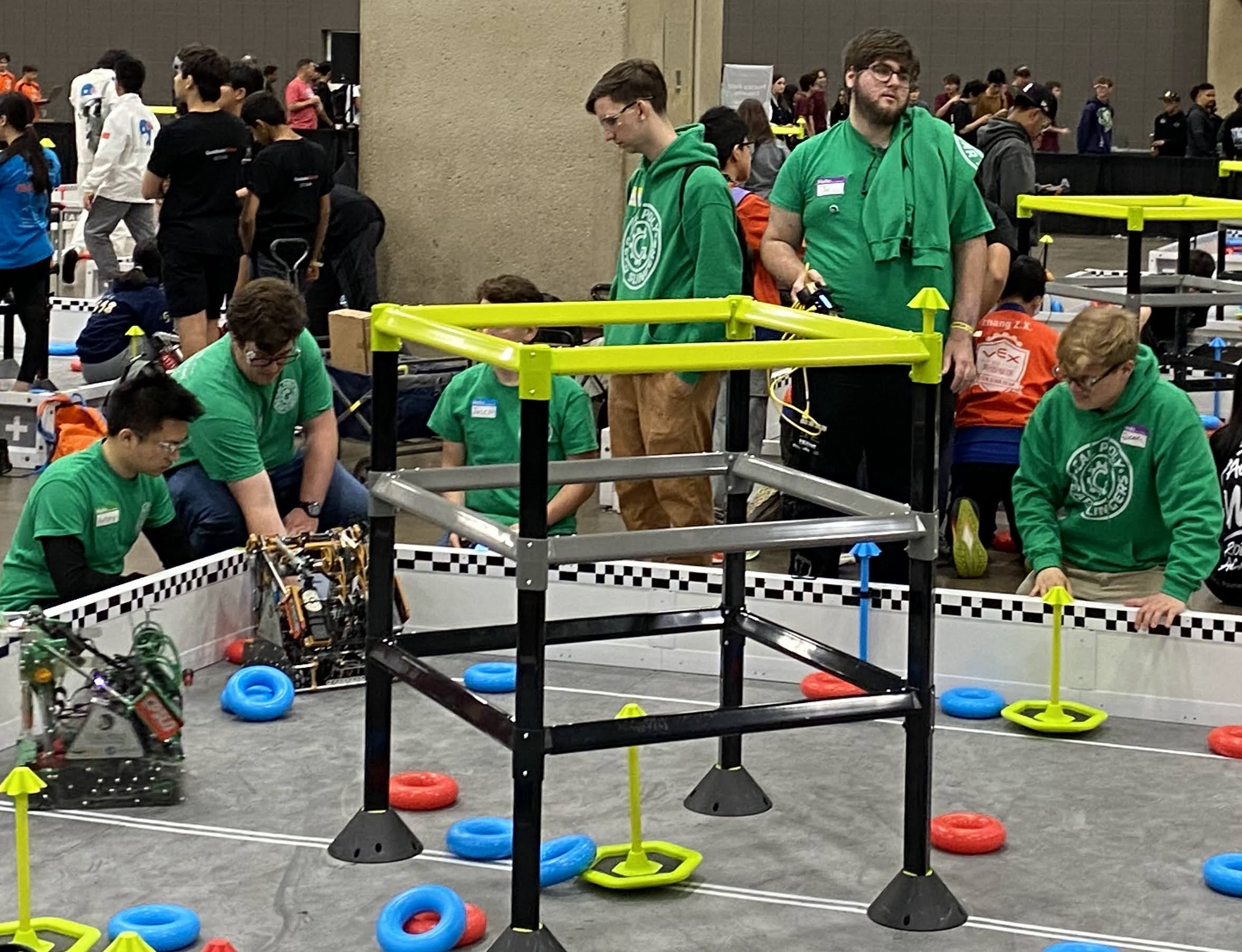 Team members ready their robots for competition on the High Stakes field