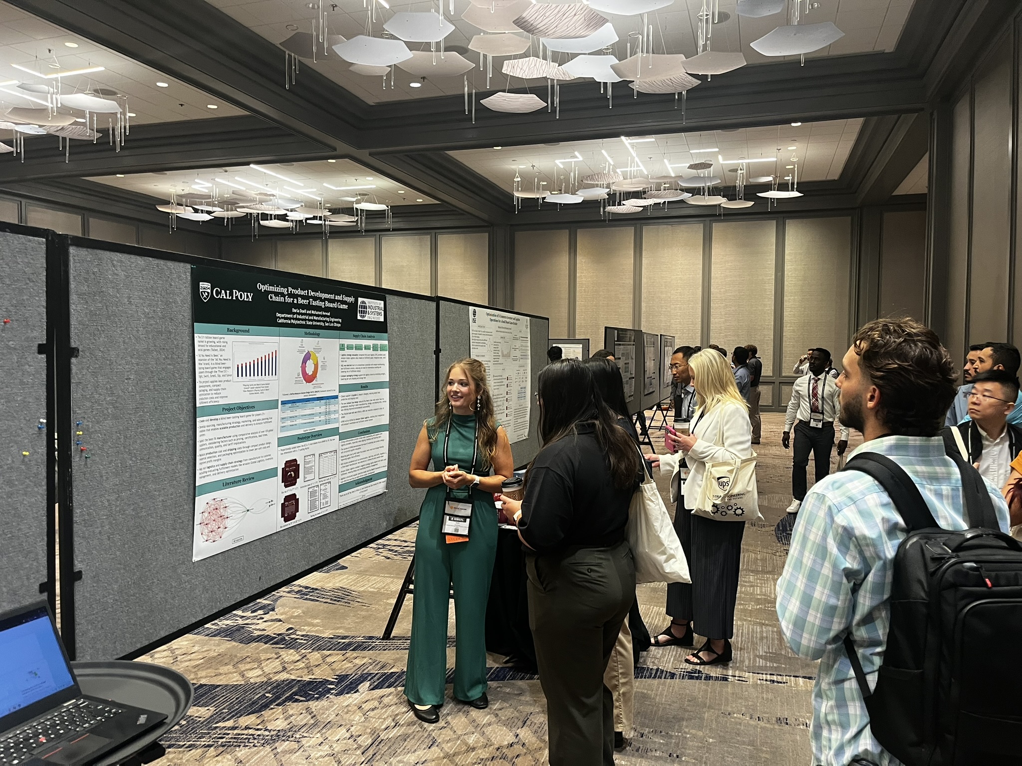 A student presenting her research poster to other students at a conference.
