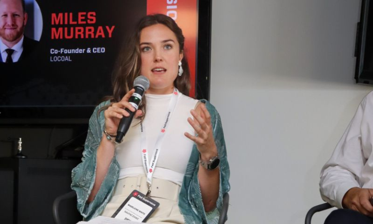A woman holding a microphone and speaking at an event