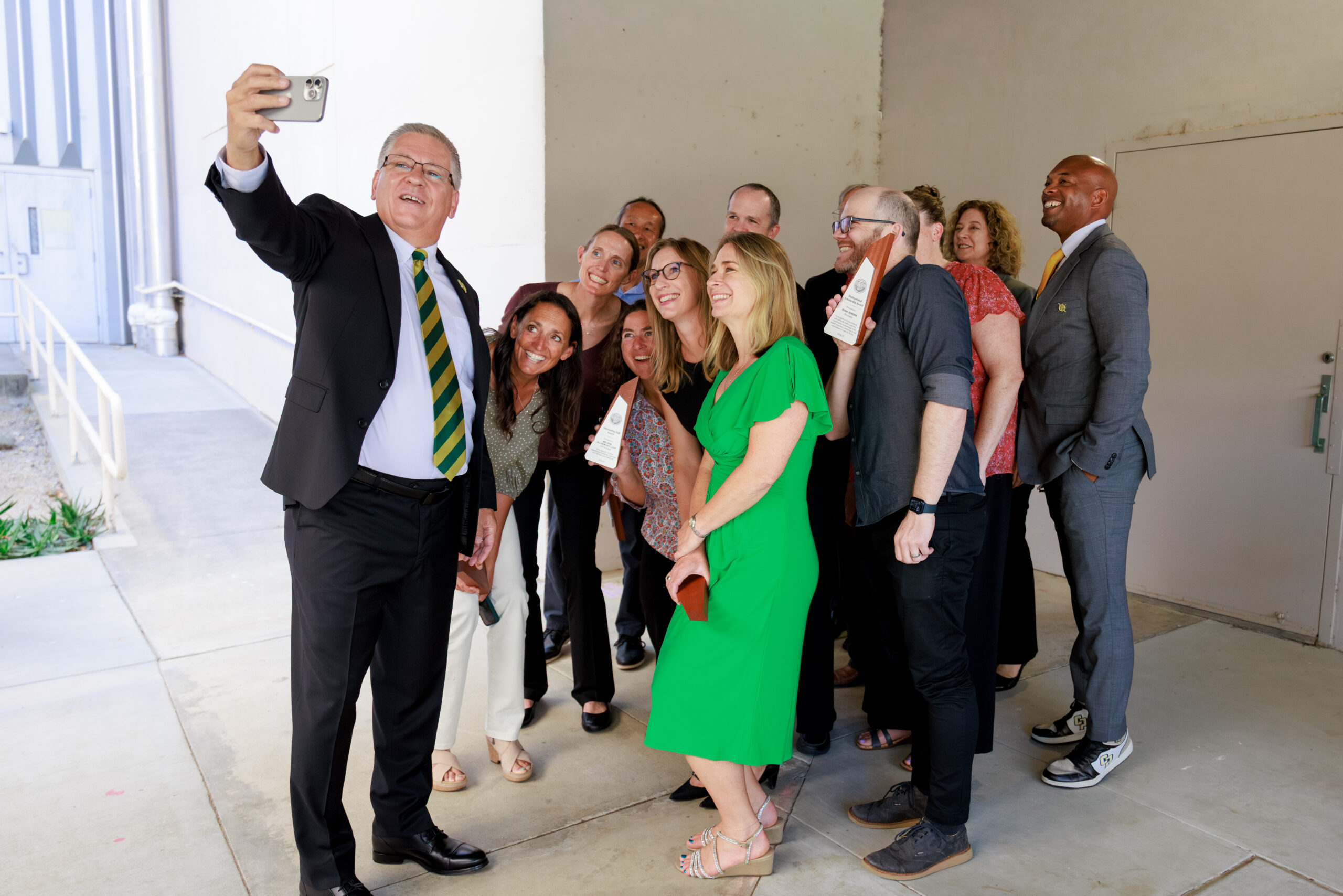 University president takes selfie with award winners