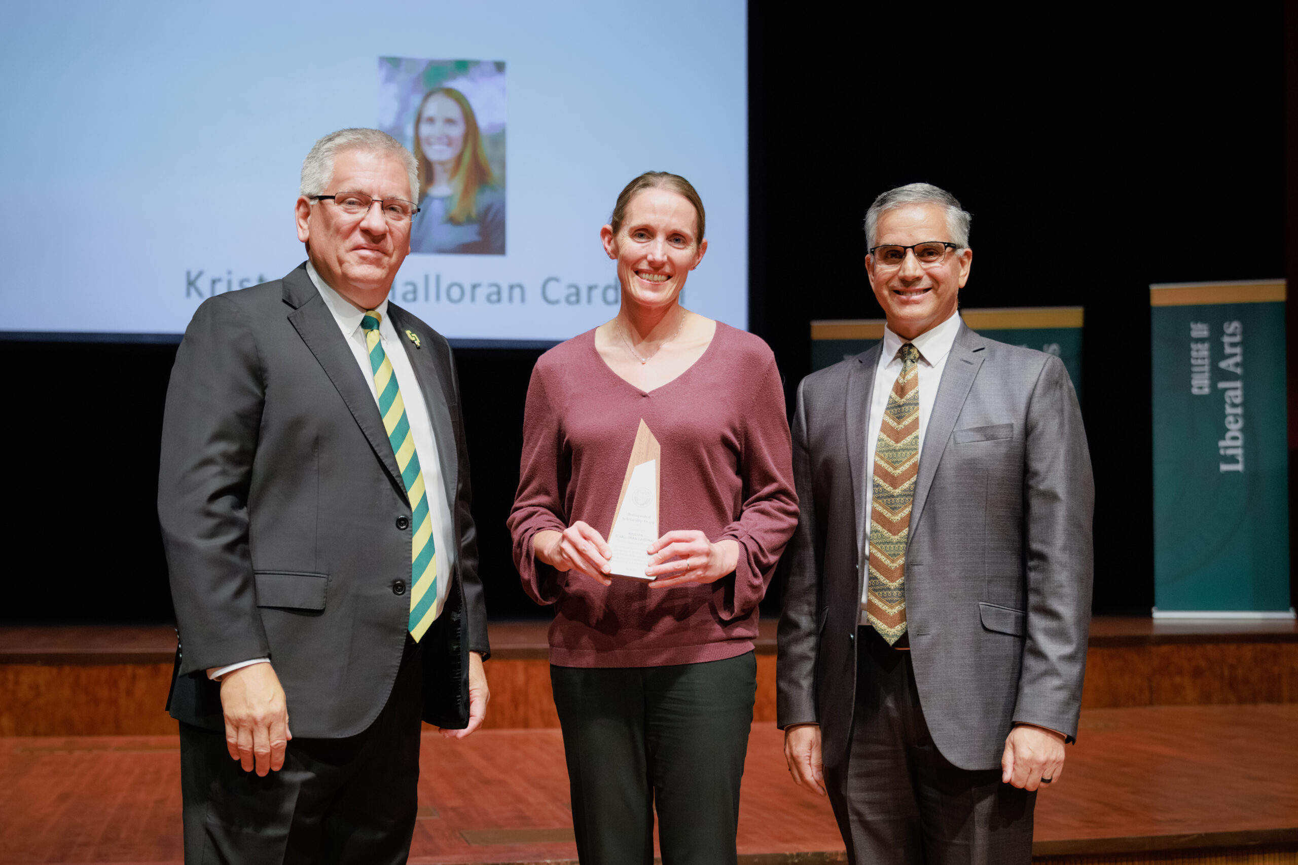 Professor stands with leadership after receiving her award
