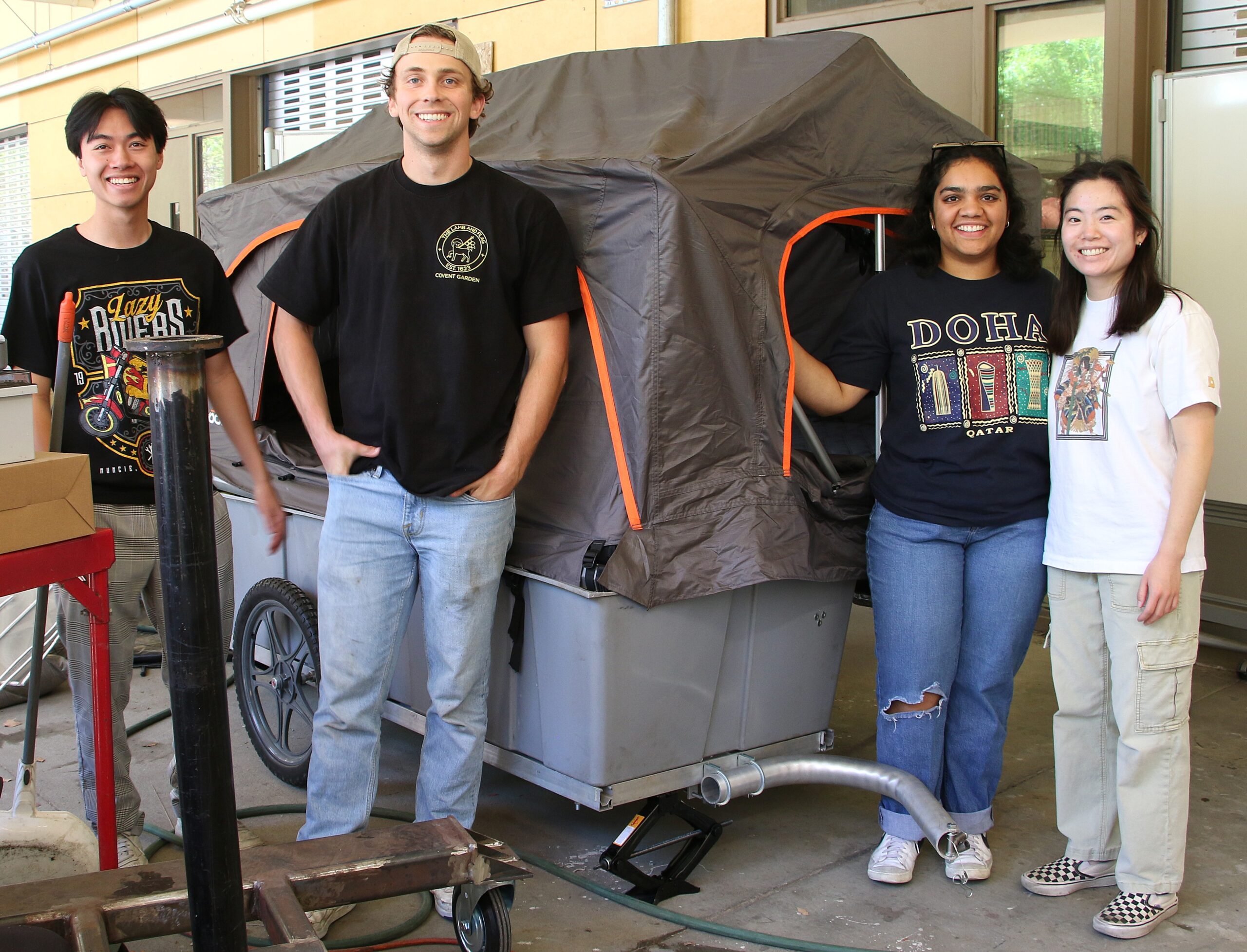 Students pose with their micromobile home outside the machine shop