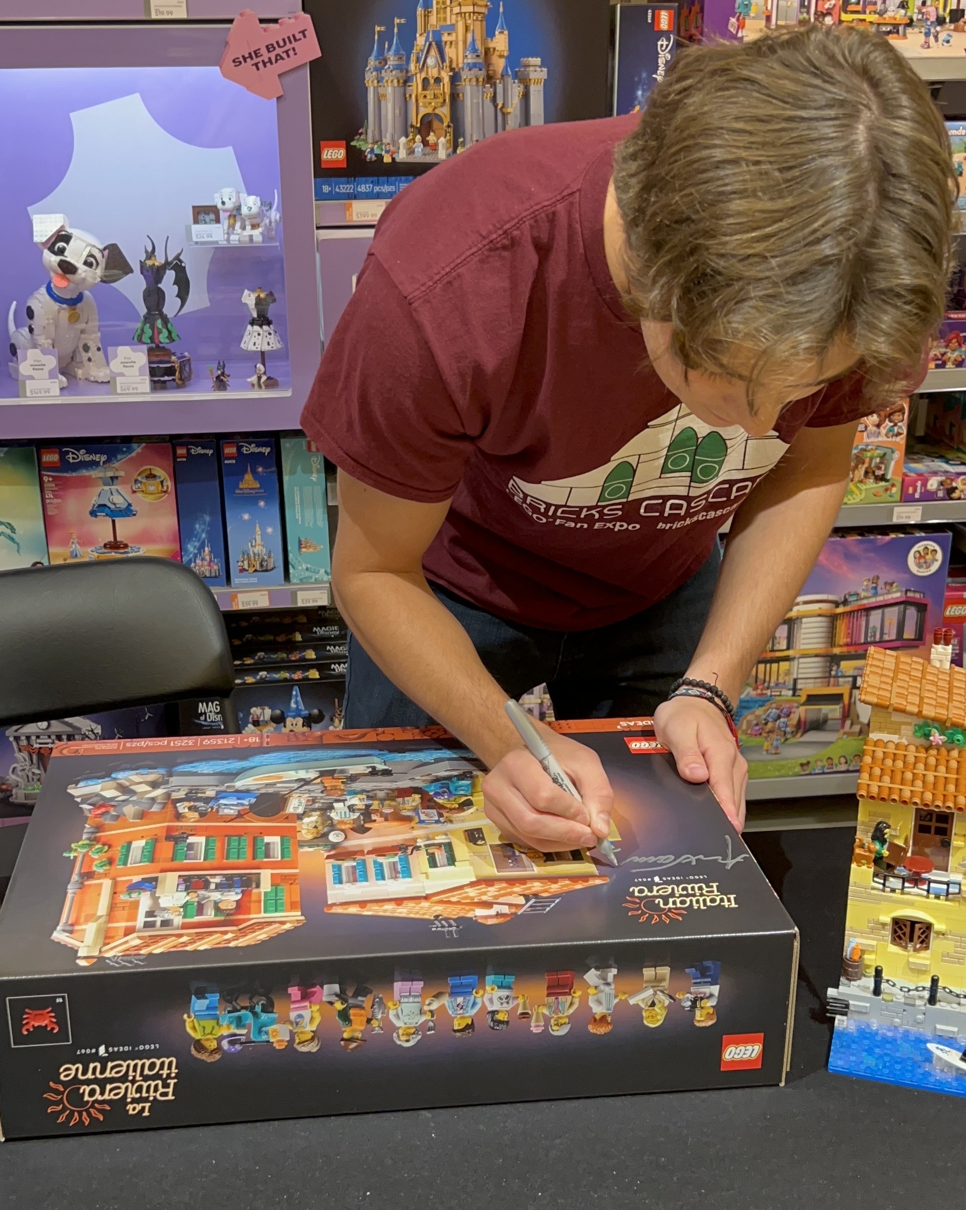 Student signing Lego box