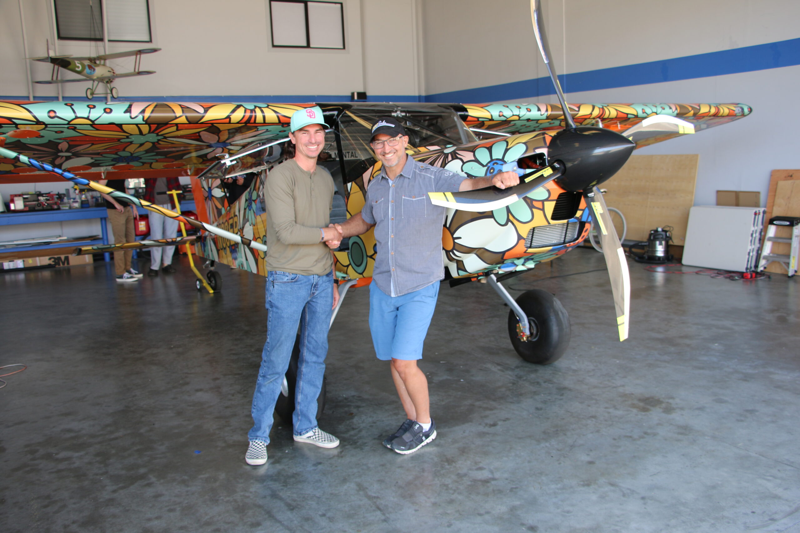 Professor and alumnus stand in front of the airplane