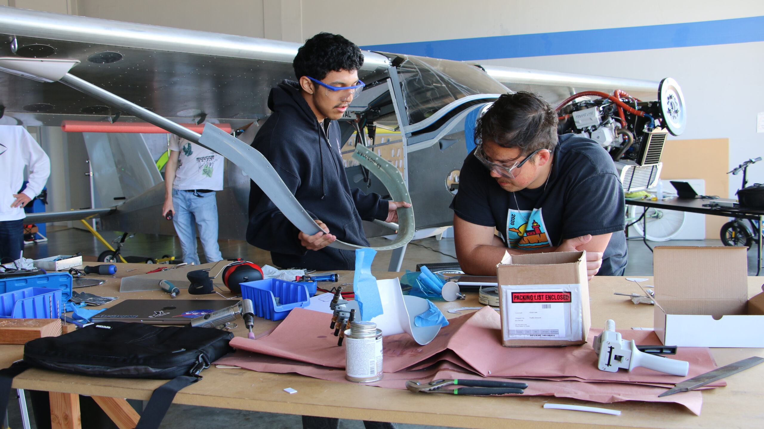 Students complete final assembly work in the airport hangar