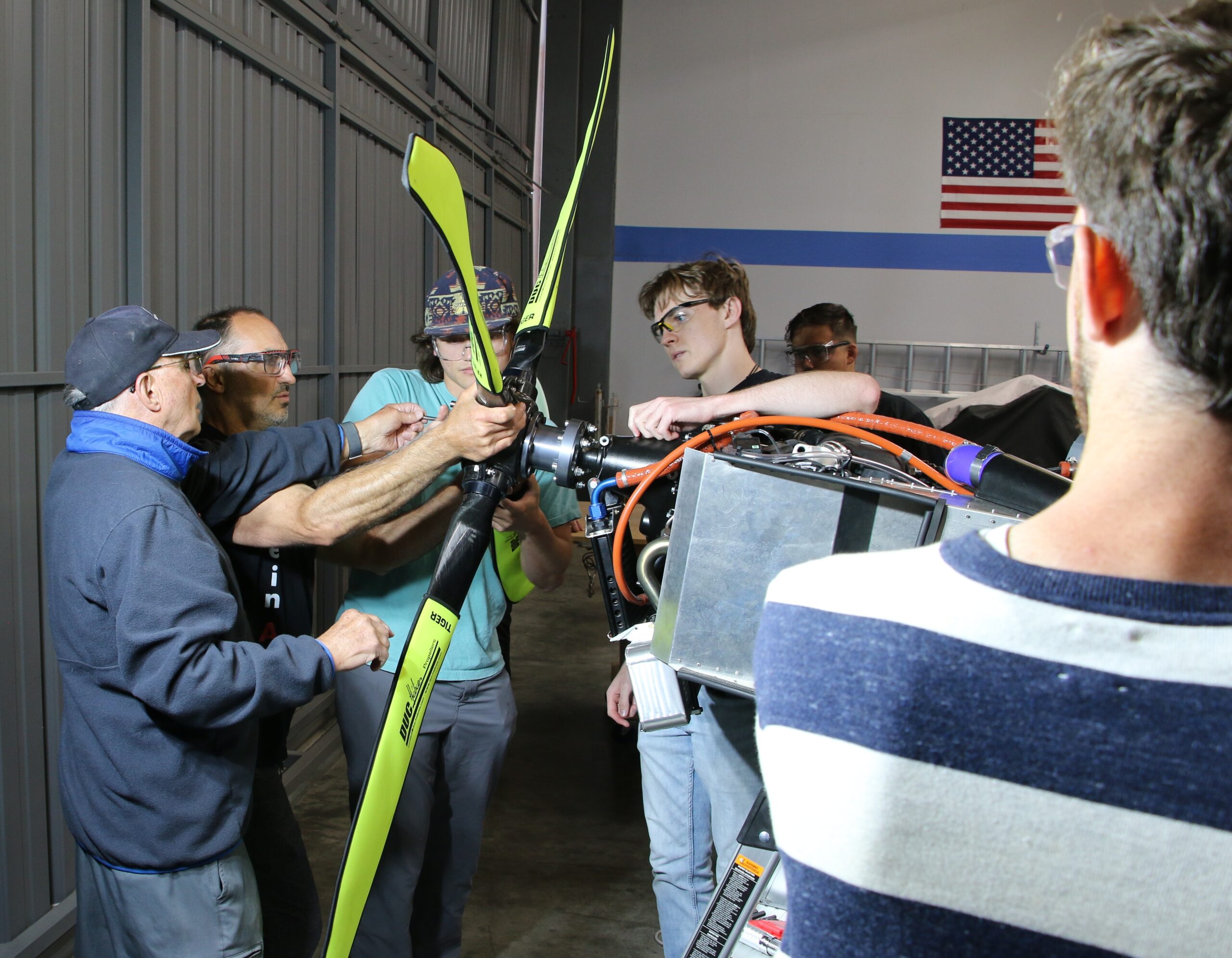 Professor, his dad and students attach the airplane's propeller