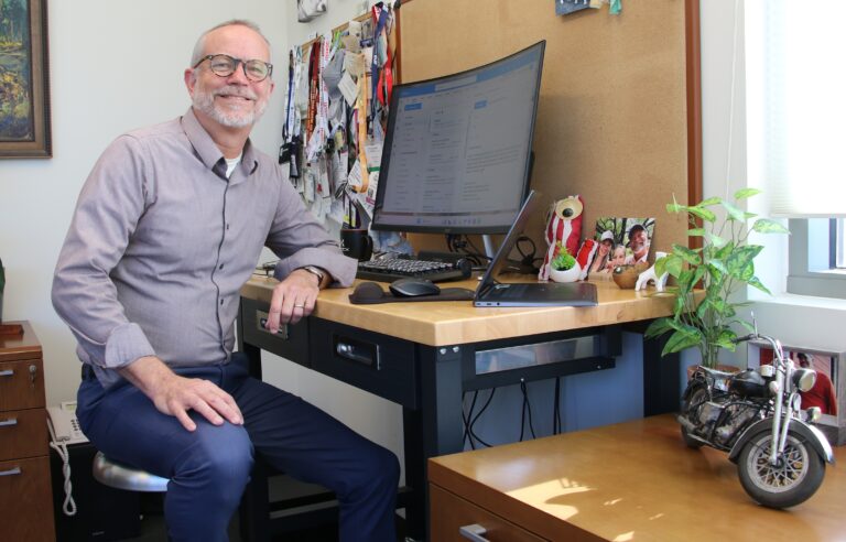 Dean sitting behind his desk