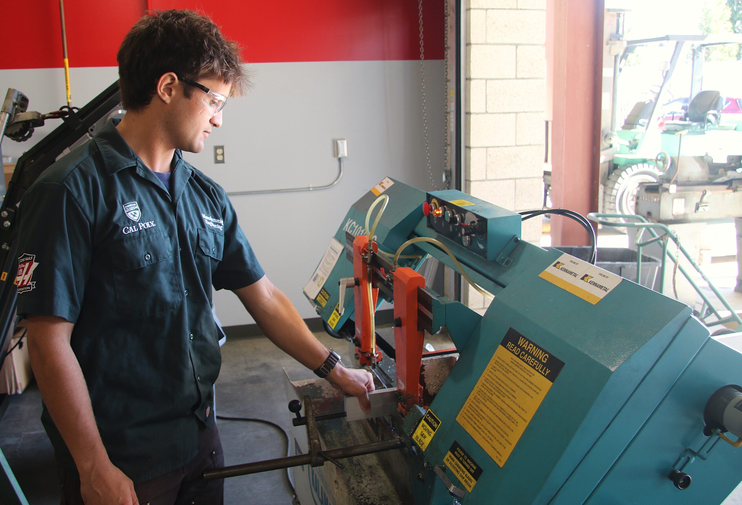 Student lab tech works with horizontal band saw