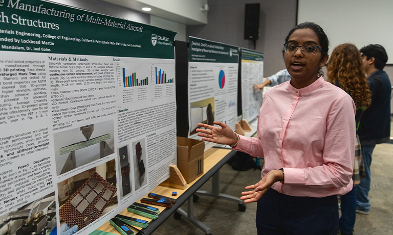 Student displays poster during symposium