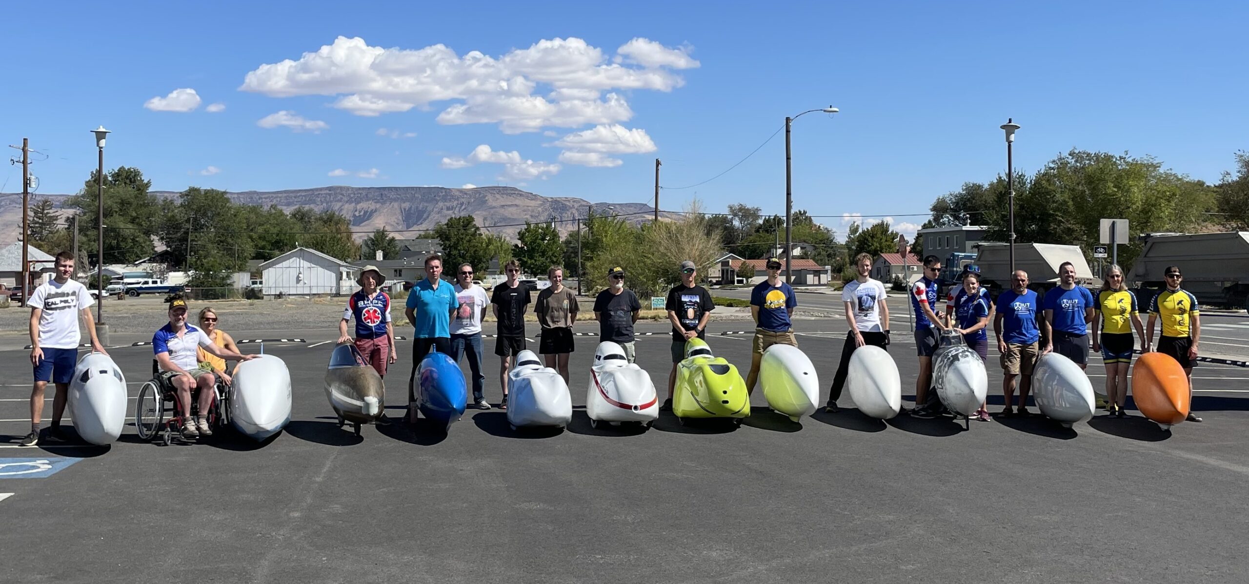 Riders from 12 teams pose with their vehicles
