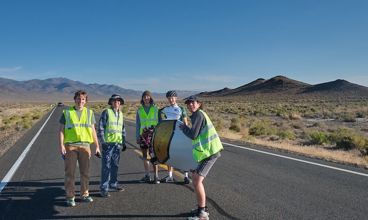 Students hold their human-powered vehicle on the highway