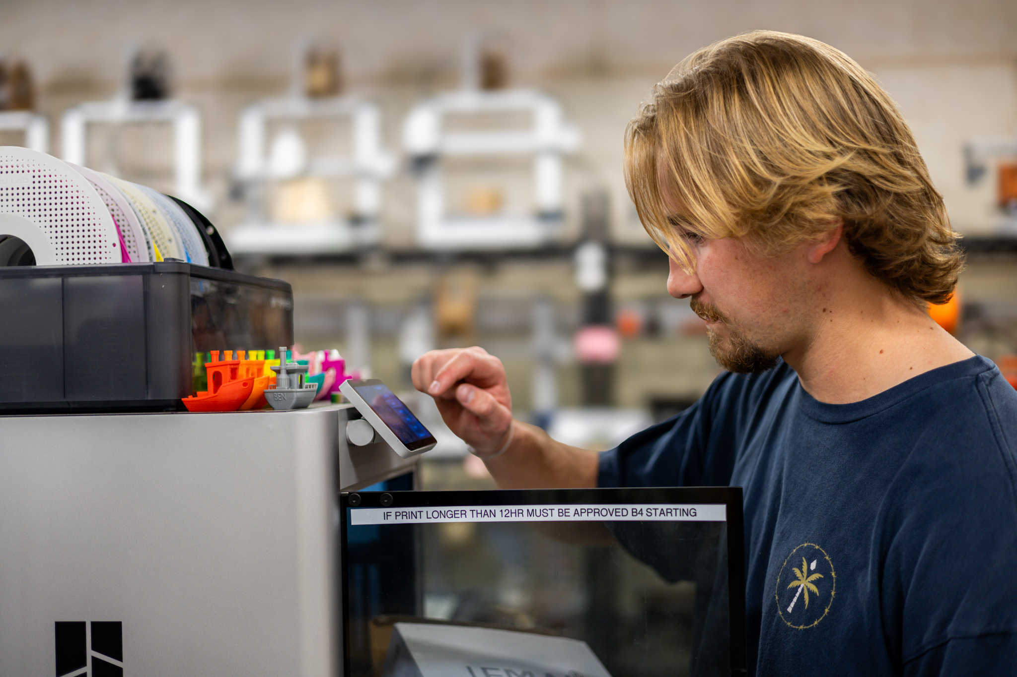 Student adjusts filament on 3D printer