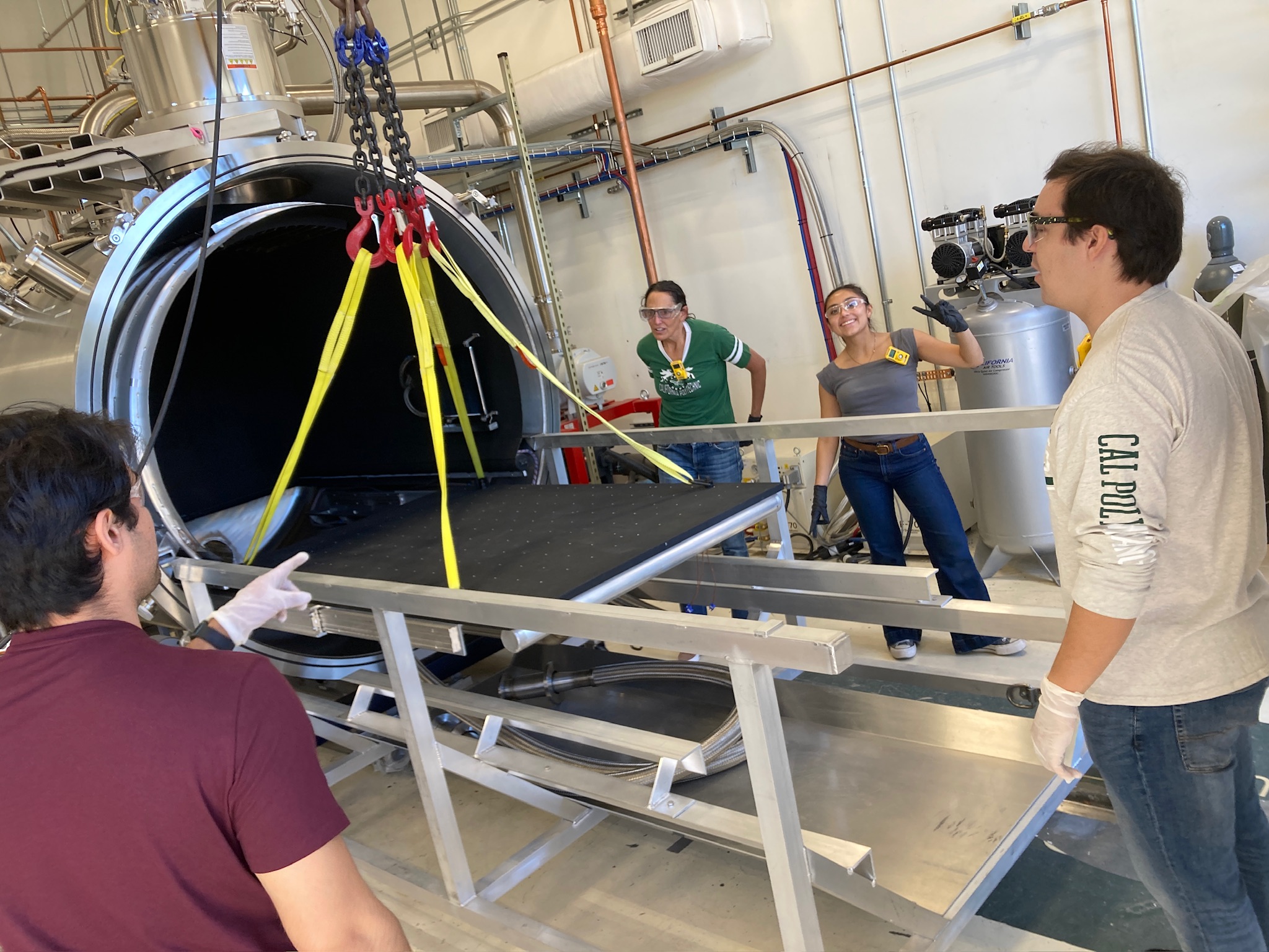 Students and professor remove thermal vacuum platen