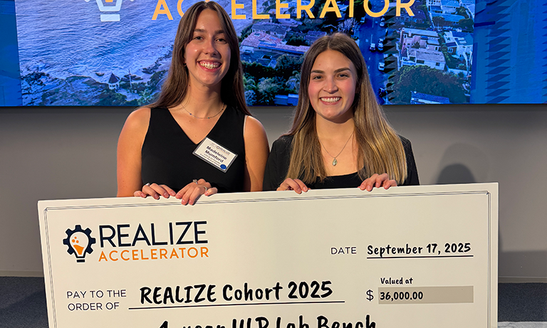 Co-founders hold up giant check