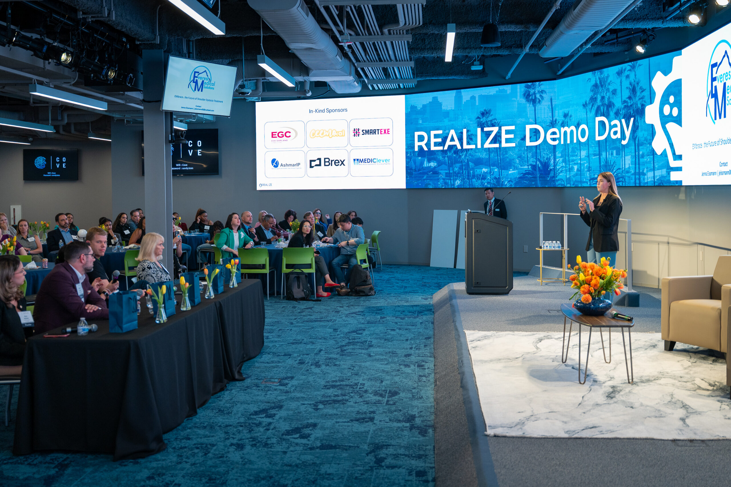Jenna presents in front of an audience during REALIZE Accelerator Demo Day
