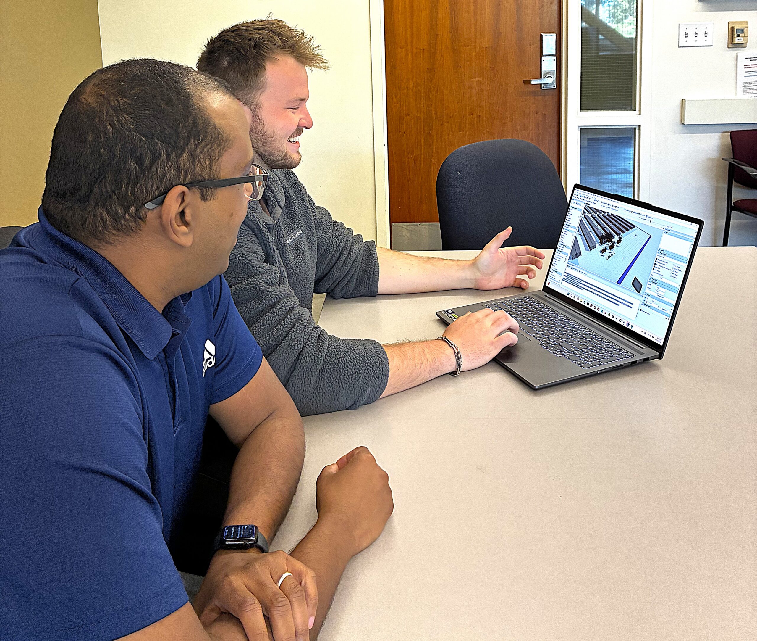Professor and student work at laptop