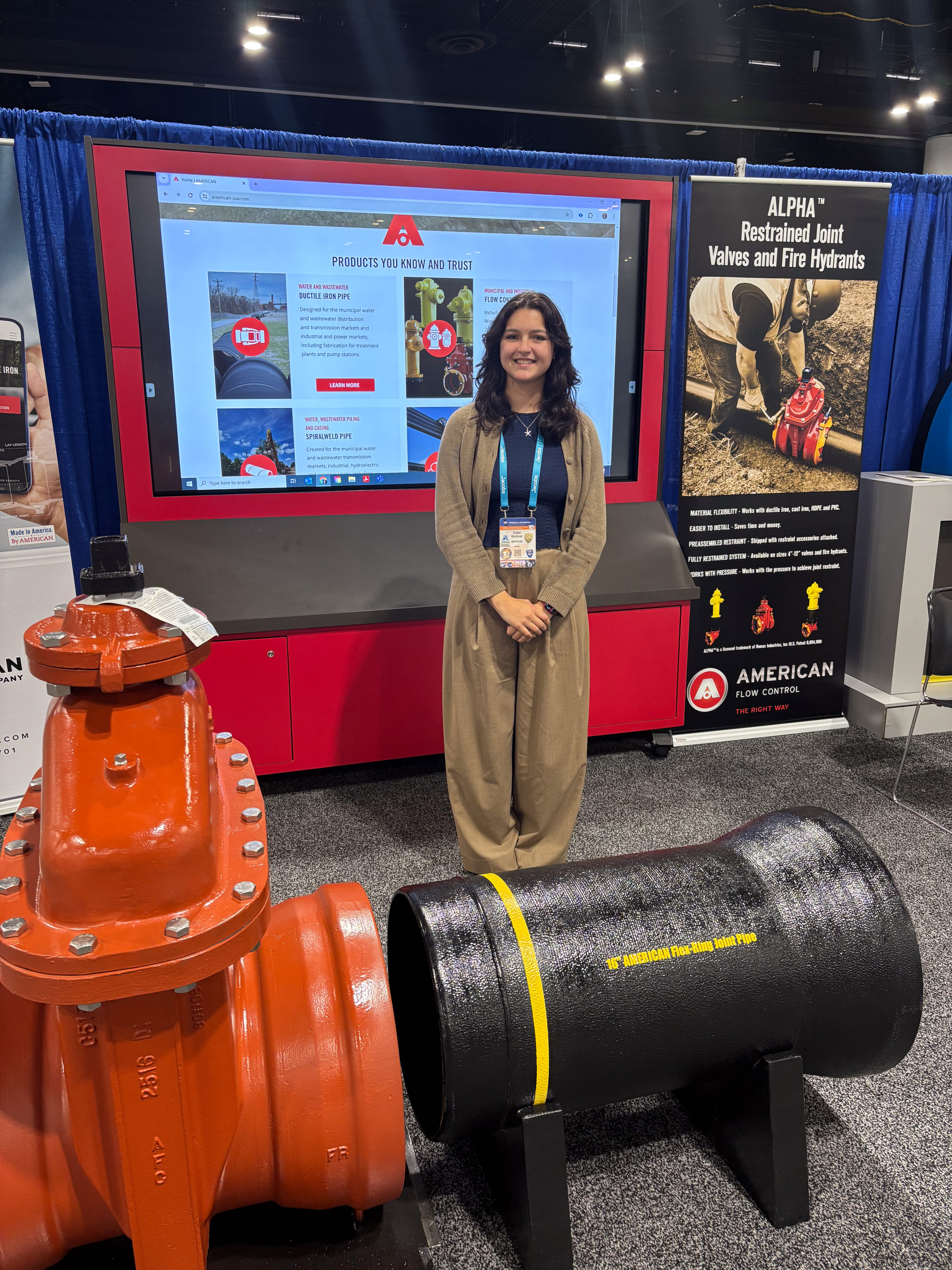 Student stands at booth during conference