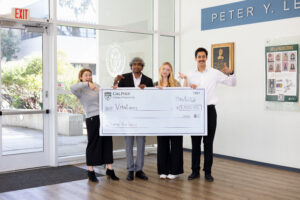 Four students holding a giant check